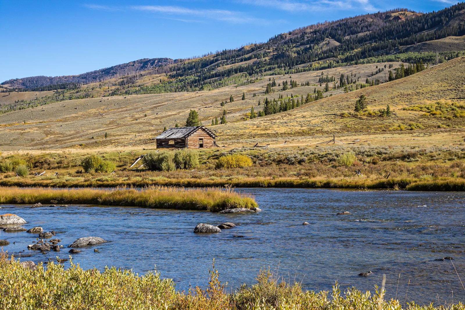 a house on the side of a mountain with a river running through it